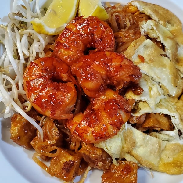 Close-up of Baan Thai's Pad Thai with shrimp, tofu, bean sprouts, and lemon wedges.